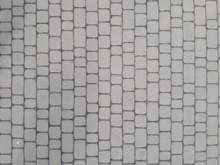 Texture of street tiles. Pattern of gray sidewalk tiles close up © Larysa