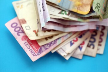 Ukrainian money bills on light blue paper background