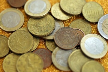Big amount of euro coins on golden glitter background