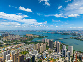 Fototapeta premium Expansive aerial view of Tangxun Lake in Jiangxia District, Wuhan, China, showcasing a vibrant cityscape with numerous buildings and bridges under a clear blue sky.