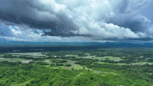Aerial view of green fields interspersed with trees create a vibrant landscape under a dramatic sky, Ramu, Chittagong Division, Bangladesh.