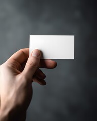 Fototapeta premium Hand holding a plain white card in studio style perfect for text insertion branding and marketing concepts