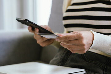 A young woman uses a laptop and credit card for online shopping, symbolizing modern finance, digital payments, e-commerce, banking, and technology-driven consumer lifestyles in today’s connected world