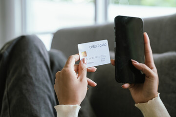 A young woman uses a laptop and credit card for online shopping, symbolizing modern finance, digital payments, e-commerce, banking, and technology-driven consumer lifestyles in today’s connected world
