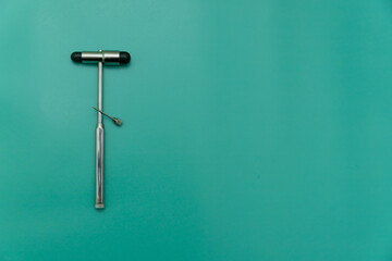 medical hammer and medical needle on green Background, Space for Text, Space for Logo