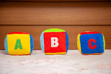 Children's plush dice with the writing A B C.