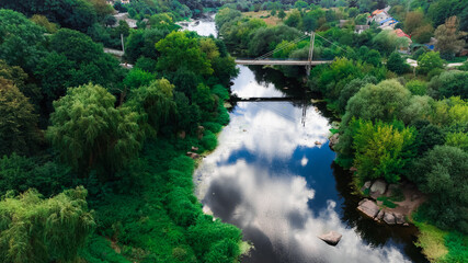 outskirts settlement third world aerial country side greenery land small river stream along rural space and miniature bridge top drone photography