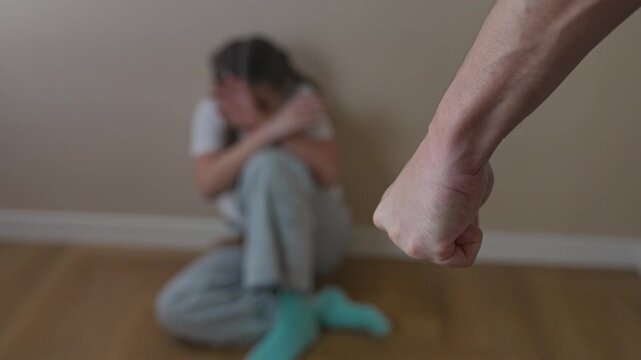 Girl shows fear sitting in room corner. Trauma visible in folded arms. Girl retreats in silence. Fear surrounds girl in corner. Trauma repeats in scene. Girl sits holding fear and trauma again