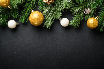 Christmas decorations and spruce tree at black background.