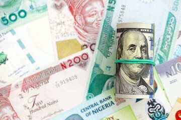 Nigerian naira currency money bills and bunch of us dollar banknotes close up. The concept of economics and currency exchange