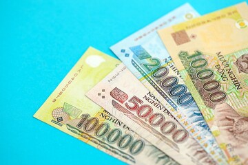 Vietnamese dong money bills in big amount close up on blue. Finance and banking concept