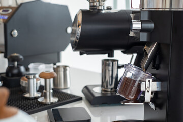 Professional espresso machine brewing fresh coffee shot into a glass measuring cup in modern caf&eacute;. Close-up of barista equipment for quality coffee preparation and caffeine concept.