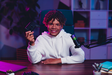 Young gamer streaming live podcast at home with gaming gear and professional microphone