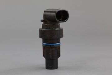 Sensor speed Allison transmission, A black plastic sensor with a metal fitting and a blue O-ring on a solid gray background. 