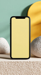 A sleek smartphone, radiating modern minimalism, with a bright yellow screen, is artfully arranged amidst a display of stones and abstract geometric shapes.