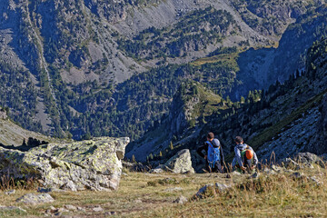 CHAMROUSSE, FRANCE, August 24, 2025 : Two hikers on the path to the via ferrata spot and beautiful surrounding mountain landscapes