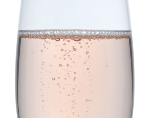 A sparkling beverage in a glass, featuring effervescent bubbles and a soft pink hue.