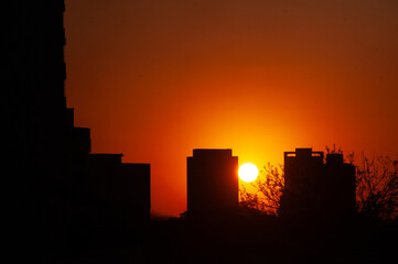 Obraz premium Por do sol entre predios