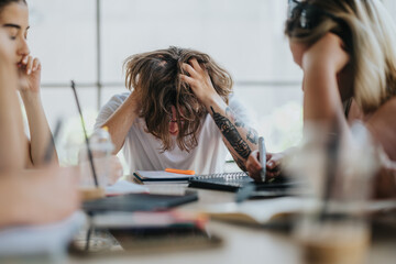 A group of students engaged in a study session, showcasing frustration and collaboration. Ideal for concepts of stress, teamwork, and education.