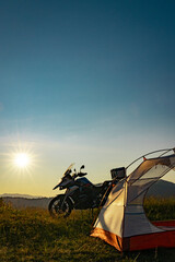 Moto trip on a motorcycle, camping in a tent in the mountains.