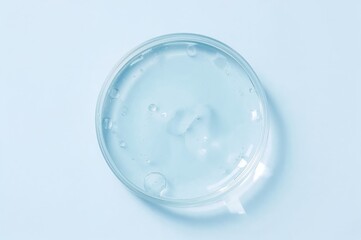 Empty circular petri dish or glass slide displayed on a plain surface. Template for cosmetic or laboratory product sample.