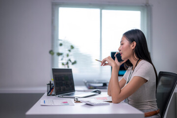 Obraz premium woman is sitting at a desk with a laptop and a cell phone