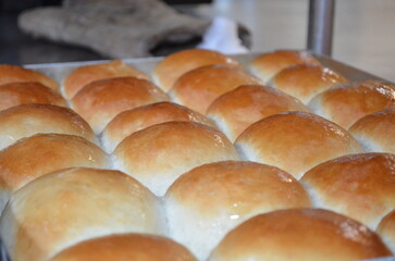 Freshly baked pav buns arranged neatly in a baking tray, golden brown on top with a soft fluffy texture, ready to be served warm.