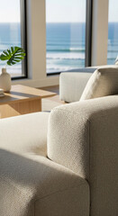 Fototapeta premium Close-up of beige fabric texture on sofa armrest, showcasing smooth, even weave. Ocean view background suggests relaxation and coastal living, ideal for home decor or furniture websites