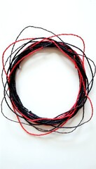 A circle of black and red wires on a white surface.