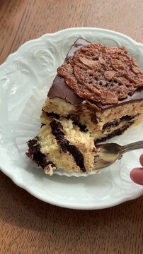 A man takes a piece of cake with a fork. Vertical. Chocolate cakes. Degustation