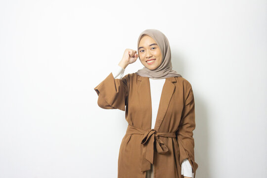 young Adult Indonesian jilbab woman clenched fist isolated white background