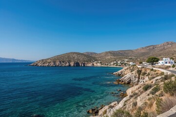 Fototapeta premium Coastline with rocky cliffs by a sea bay on a Greek island
