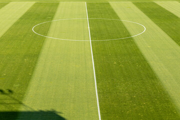 View of a soccer field. Perfectly manicured, striped green grass football pitch ready for a match. Sports background for competition and athletic concepts. © dechevm