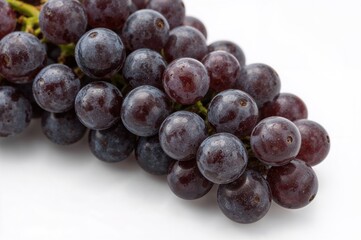 Dark grapes on a plain white backdrop.