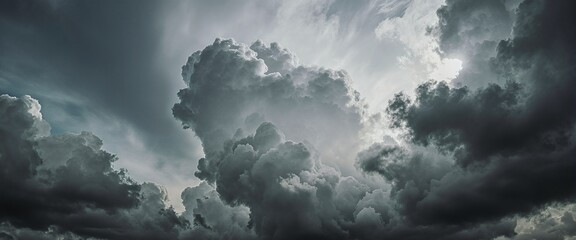 A dramatic sky filled with dark, billowing clouds, with sunlight piercing through, creating a striking contrast between light and shadow