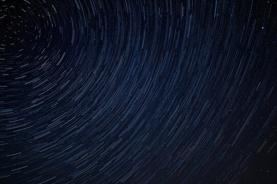 Mesmerizing long-exposure capture reveals swirling star trails lighting up the nighttime heavens in a stunning cosmic display.