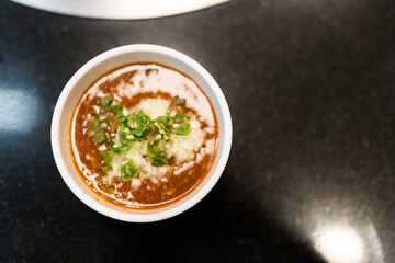 Chopped garlic and green chile in sukiyaki dipping
