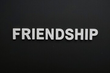 Fototapeta premium Friendship Day celebration theme with 'friends' spelled out on a dark backdrop.