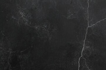 Dark toned black PVC vinyl texture on a concrete floor surface.