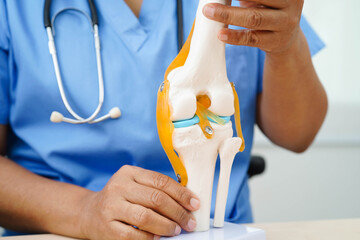 Asian doctor holding spinal nerve and bone model, Lumbar spine displaced herniated disc fragment...