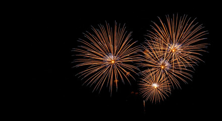 A lovely display of golden fireworks bursting in the shape of multiple hearts against a black sky a perfect romantic background for a wedding or Valentine's Day
