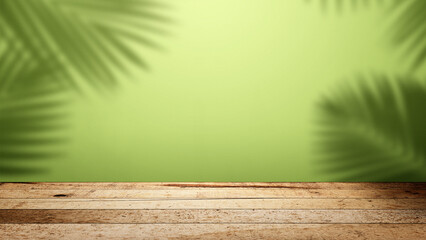 Interior of a modern and minimalist studio with the shadow of a palm leaf on a green wall with a wooden floor background. Mockup or copy space