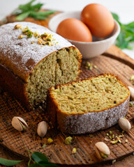 Homemade pistachio and avocado cake on a wooden surface.