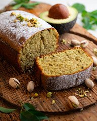 Homemade pistachio and avocado cake on a wooden surface.