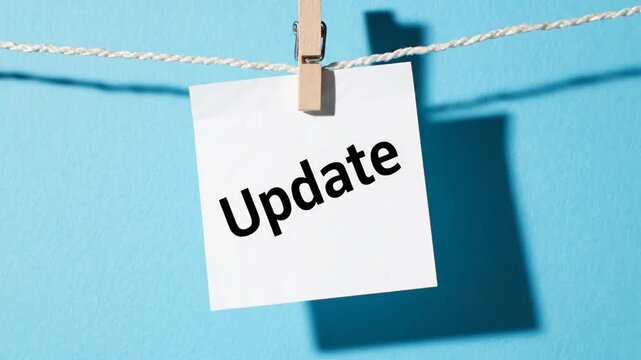 Update Text on White Square Paper Note Pinned with Clothespin on Blue Background