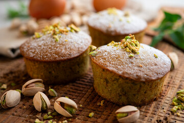 Pistachio muffins on a wooden surface.