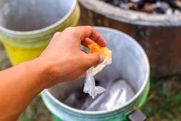 Hand Disposing Plastic Trash Into Recycling Bin Outdoors