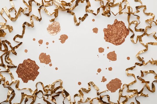 Gold and bronze patches on torn metallic leaf paper over white background. Compilation