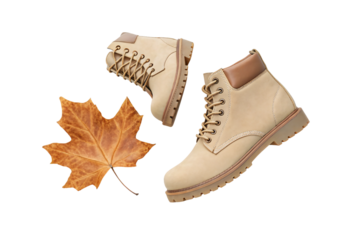 Tan leather work boots with lacing and autumn leaf seasonal footwear styling, isolated on a transparent background