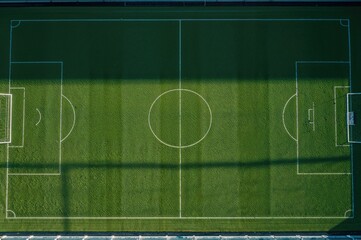 Overhead drone shot of an empty green soccer field ready for play